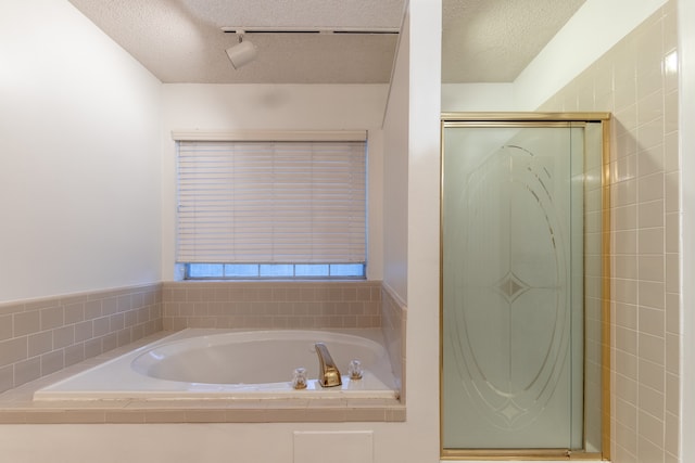 bathroom with plus walk in shower and a textured ceiling