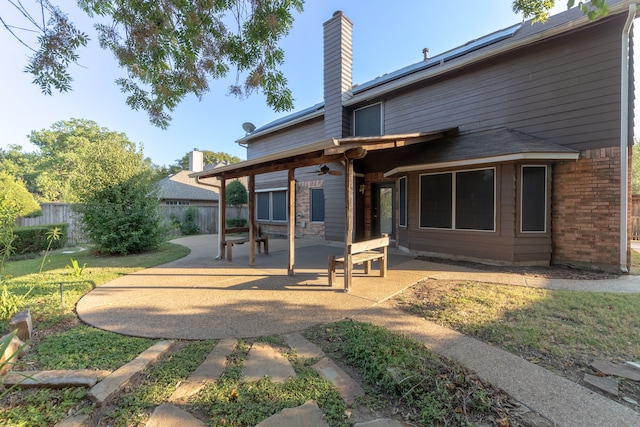 back of property with a yard and a patio area