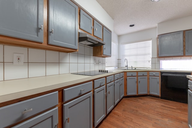 kitchen featuring gray cabinets, light hardwood / wood-style flooring, sink, black appliances, and a textured ceiling