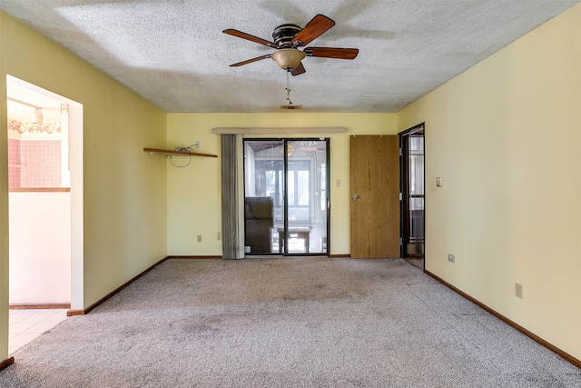 carpeted spare room featuring ceiling fan and a textured ceiling