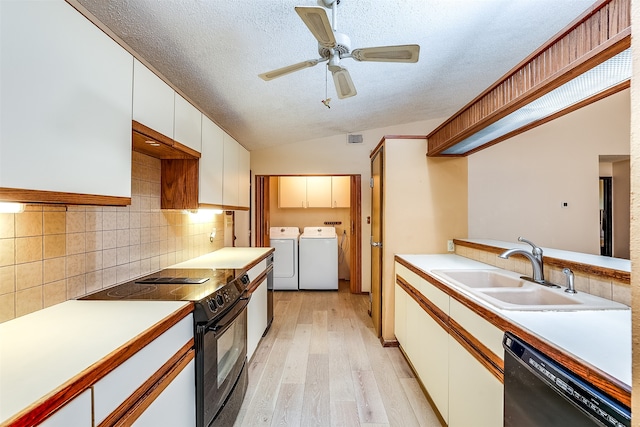 kitchen featuring lofted ceiling, black appliances, sink, light hardwood / wood-style flooring, and washing machine and dryer