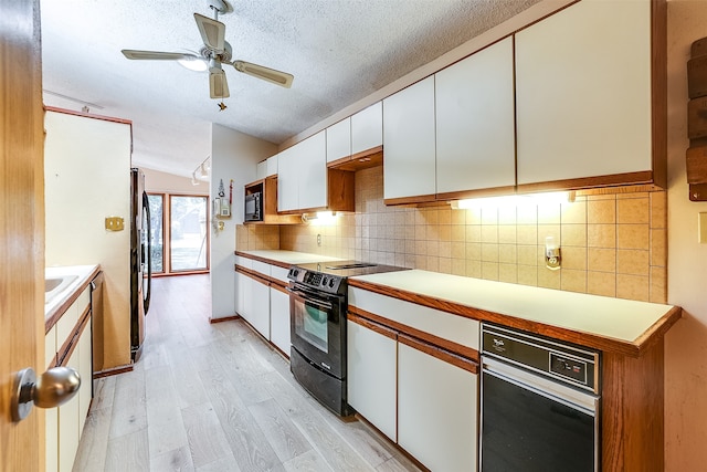 kitchen featuring stainless steel fridge, light wood-type flooring, black range with electric cooktop, white cabinets, and a textured ceiling