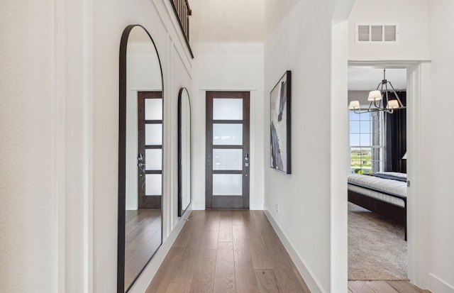 interior space featuring light hardwood / wood-style floors and an inviting chandelier