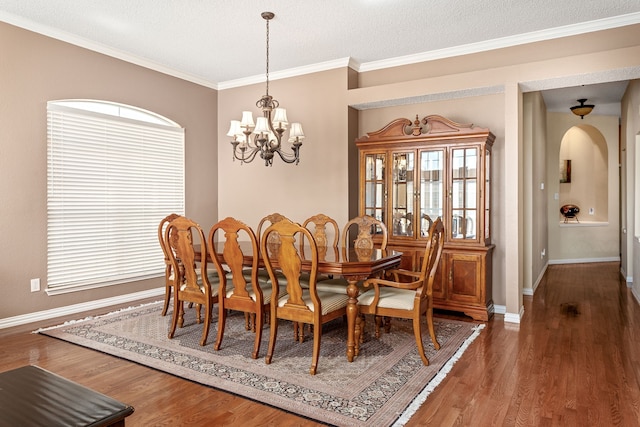 dining space with an inviting chandelier, ornamental molding, dark hardwood / wood-style flooring, and a textured ceiling