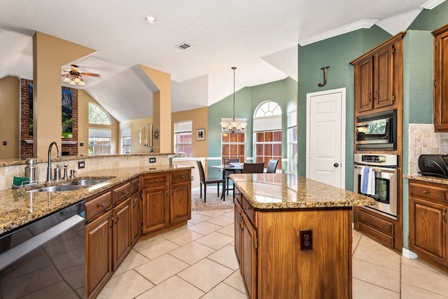 kitchen featuring stainless steel appliances, sink, a center island, and a textured ceiling