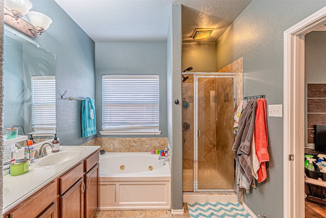 bathroom with plus walk in shower, vanity, and a textured ceiling