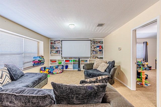 game room with light colored carpet and a textured ceiling