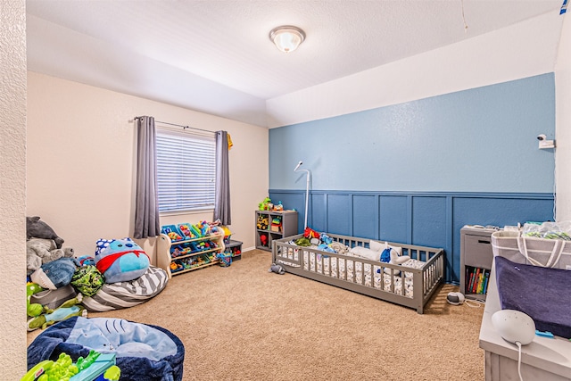 bedroom featuring a nursery area and carpet flooring