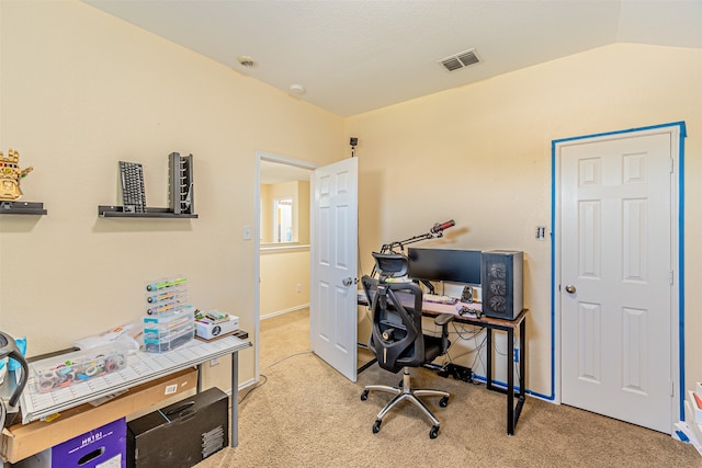 carpeted home office featuring vaulted ceiling