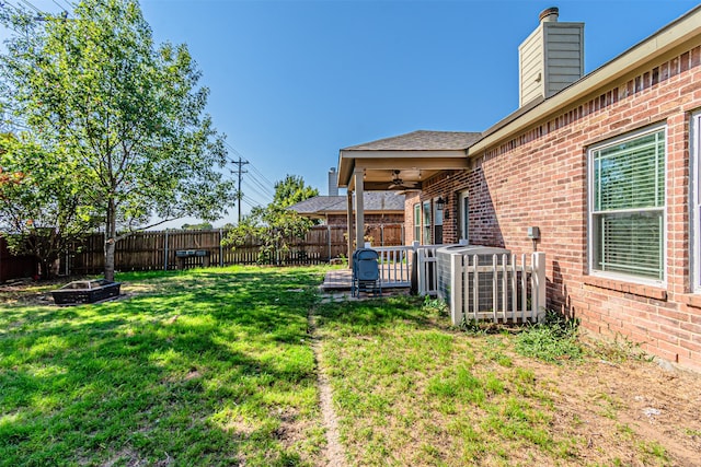 view of yard with a fire pit and ceiling fan