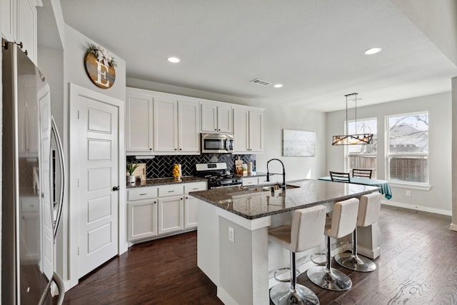 kitchen featuring stainless steel appliances, dark wood-type flooring, and white cabinetry