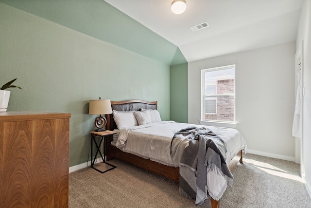 bedroom with vaulted ceiling and light colored carpet