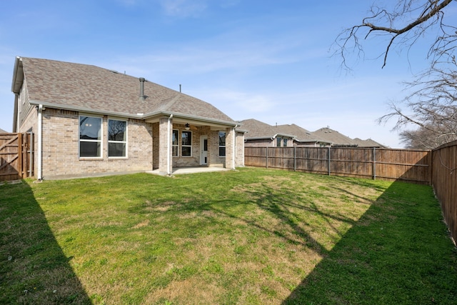 rear view of property featuring a lawn and a patio