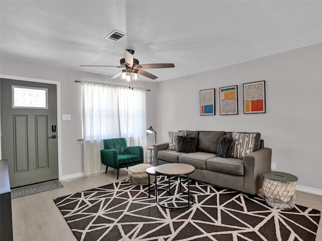 living room with ceiling fan and light hardwood / wood-style flooring