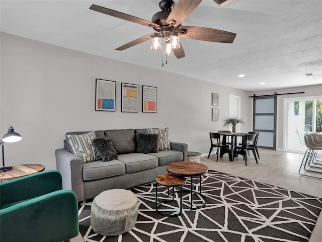 living room featuring ceiling fan and a barn door