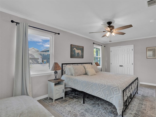 bedroom featuring multiple windows, ceiling fan, and crown molding