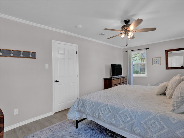 bedroom with ceiling fan, ornamental molding, and hardwood / wood-style floors