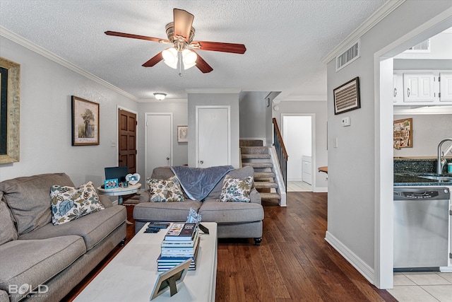 living room featuring hardwood / wood-style flooring, crown molding, ceiling fan, and a textured ceiling