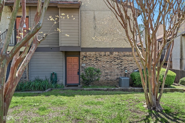 exterior space featuring a yard and central AC