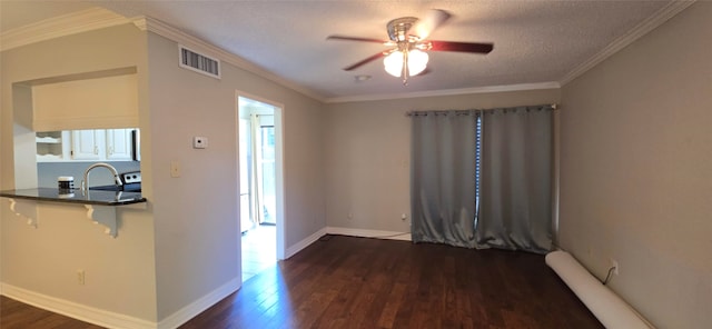 unfurnished room featuring dark wood-type flooring, crown molding, a textured ceiling, and ceiling fan