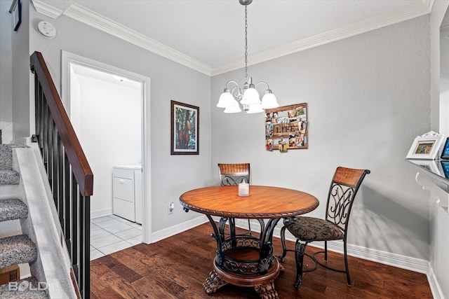 dining area featuring light hardwood / wood-style floors, crown molding, washer / clothes dryer, and an inviting chandelier