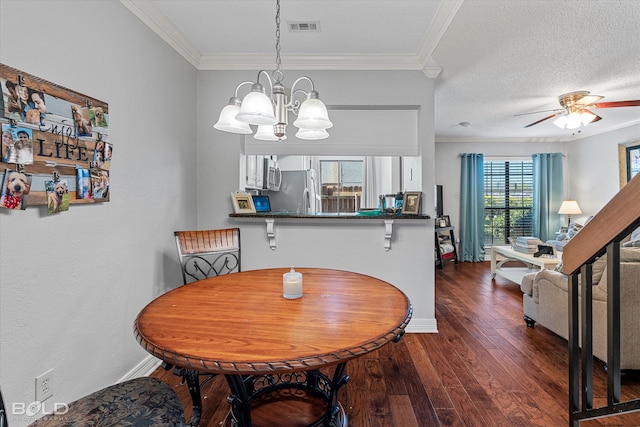 dining space with ceiling fan with notable chandelier, dark hardwood / wood-style floors, ornamental molding, and a textured ceiling