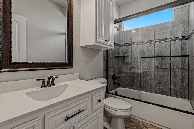 full bathroom featuring vanity, toilet, tile patterned flooring, and bath / shower combo with glass door