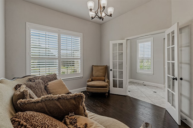 living area featuring an inviting chandelier, hardwood / wood-style flooring, and french doors