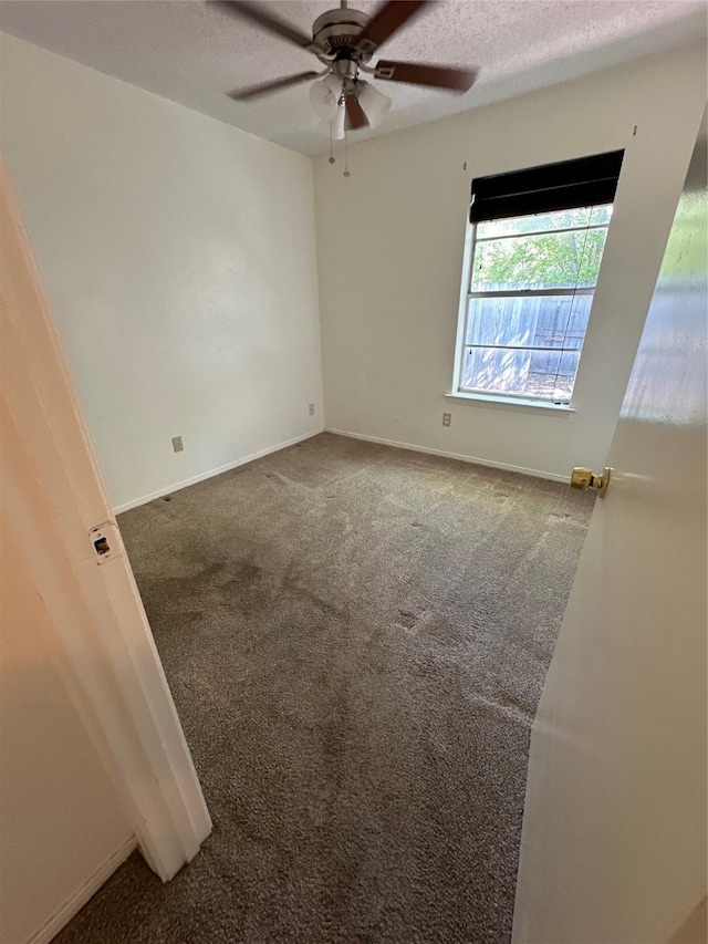 carpeted empty room with ceiling fan and a textured ceiling