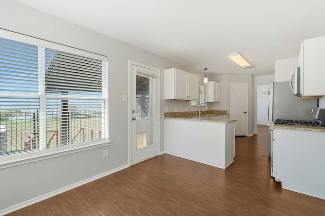 kitchen with hanging light fixtures, white gas range oven, white cabinetry, and dark hardwood / wood-style floors