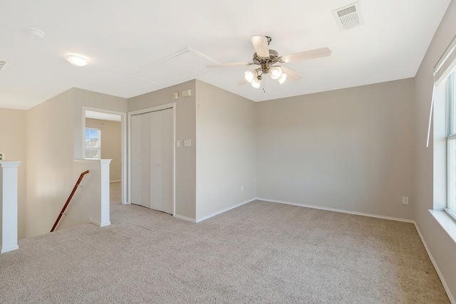 unfurnished room with light colored carpet and ceiling fan