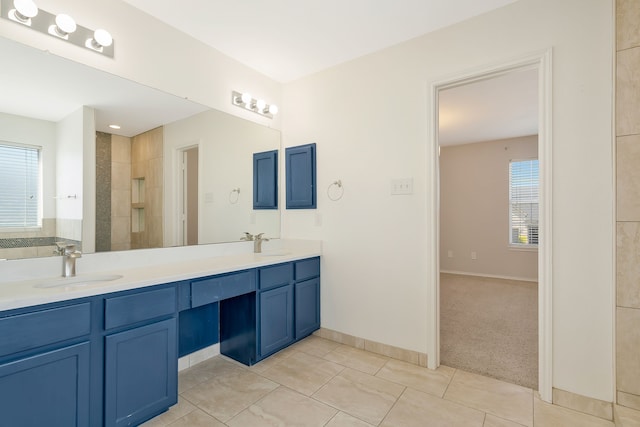 bathroom featuring tile patterned floors, a wealth of natural light, vanity, and a tile shower