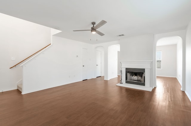 unfurnished living room with ceiling fan and dark wood-type flooring