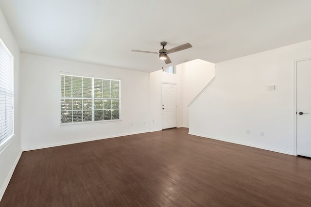 unfurnished living room with ceiling fan and dark wood-type flooring