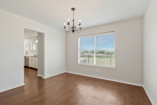 empty room featuring dark hardwood / wood-style floors, a chandelier, and sink