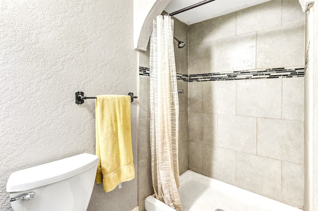 bathroom featuring toilet and walk in shower