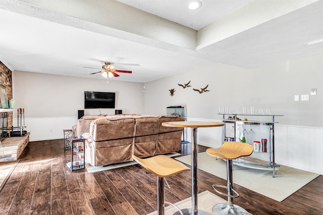 living room with ceiling fan and dark wood-type flooring