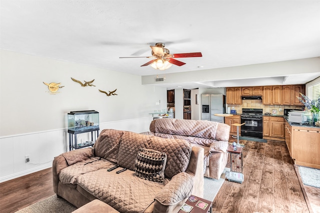 living room with ceiling fan and dark hardwood / wood-style floors