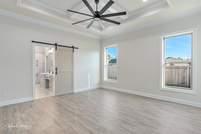 unfurnished bedroom with a barn door, ensuite bath, light hardwood / wood-style floors, and ornamental molding