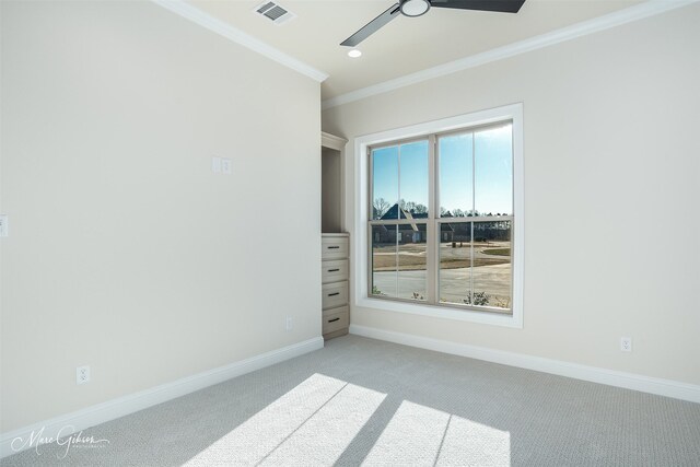 empty room featuring ceiling fan, ornamental molding, and light carpet