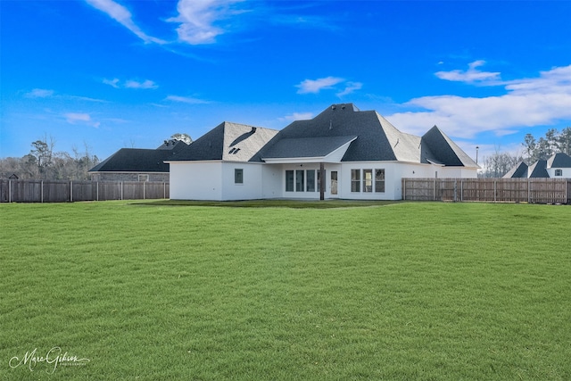 rear view of house featuring a yard