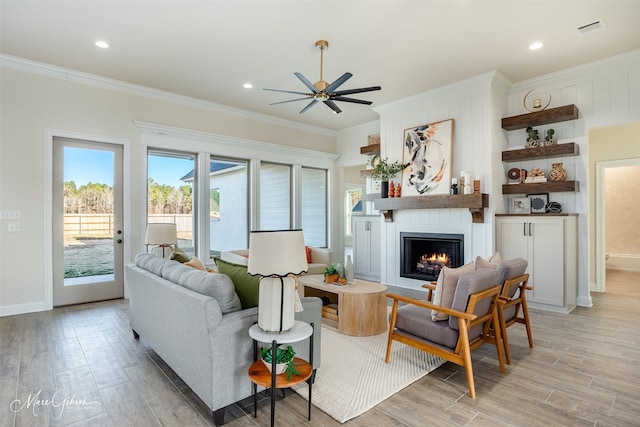 living room with crown molding, a fireplace, and ceiling fan