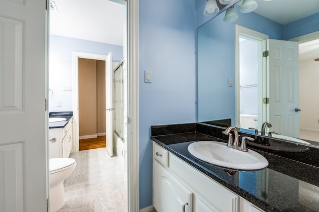 bathroom with toilet, a shower with door, and vanity