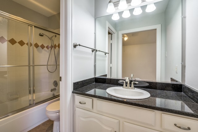 full bathroom with combined bath / shower with glass door, vanity, and toilet