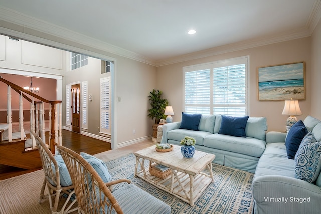 living room featuring hardwood / wood-style flooring, ornamental molding, and a chandelier