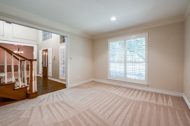 empty room featuring carpet floors, crown molding, and a notable chandelier