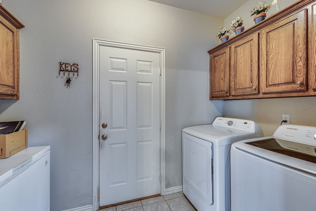 washroom featuring light tile patterned flooring, cabinets, and separate washer and dryer