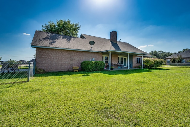 rear view of property with a lawn and a patio area