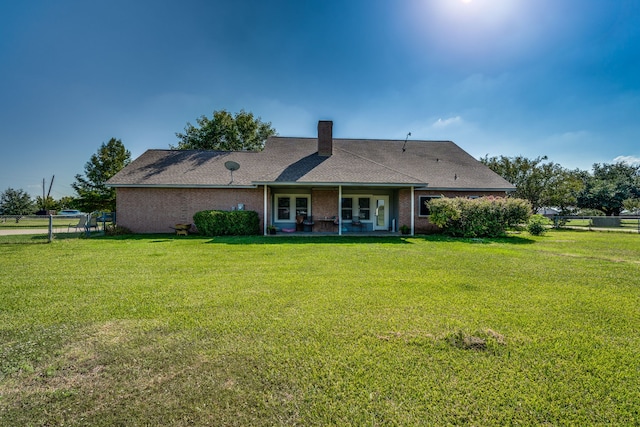 rear view of house with a lawn and a patio area