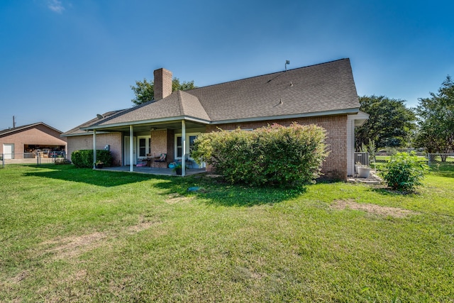 rear view of house with a yard and a patio